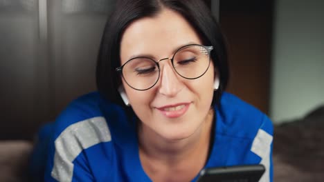 Closeup-face-of-female-in-wireless-earphone-lying-on-bed-listen-music.-Shot-with-RED-camera-in-4K