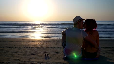 Pareja-besándose-en-la-playa-de-arena-en-hermoso-amanecer