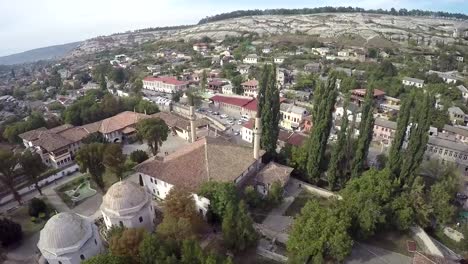 Aerial-view-on-the-old-city-with-church-before-sunset,-sunrise.-Fog,-Cloudy-sky.-Bahchisarai,-Crimea,-Russia.