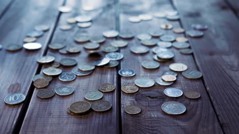 Pile-of-coins-falling-on-the-wooden-table