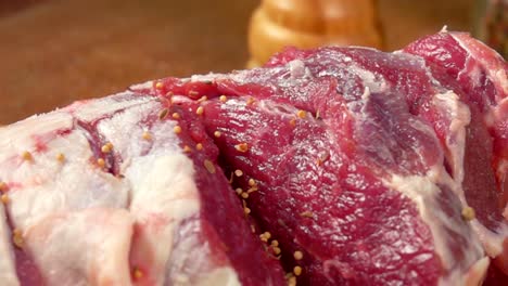 Closeup-of-spices-falls-on-the-leg-of-lamb