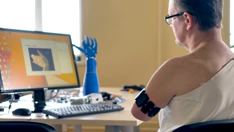 Man-with-the-amputated-arm-using-computer-with-wireless-bionic-sensors.-4K.