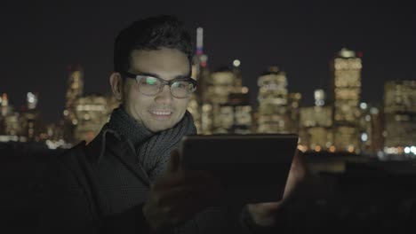 Young-Asian-Man-Using-Tablet-in-Urban-Environment.-Symbolizes-Global-Communication,-Digital-Technology,-Modern-Lifestyle