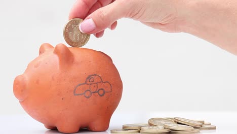 Woman-saving-money-into-a-traditional-clay-piggy-bank-for-a-car