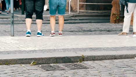 Muchos-pies-una-muchedumbre-de-personas-paseando-por-los-adoquines-de-la-ciudad