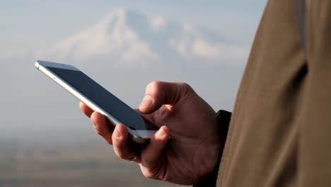 Hands-of-traveler-with-phone-in-winter-travel