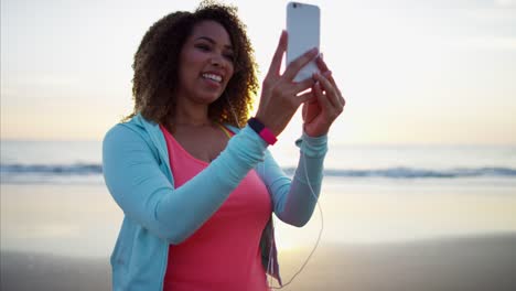 Étnica-mujer-chateando-en-teléfono-inteligente-por-océano