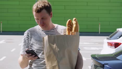 Male-with-purchases-messaging-after-left-grocery-store