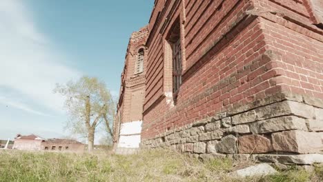 Abandoned-church-in-field-in-fall-blue-sky-prairie.-Video.-Small-chapel-in-a-field-with-yellow-flowers.-The-old-ruined-Church.-Ruins-on-the-background-of-blue-sky.-Green-grass-field