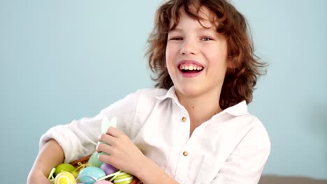 Studio-portrait-of-a-merry-boy-with-an-Easter-basket-in-his-hands.-Red-haired,-curly-blue-eyed-child