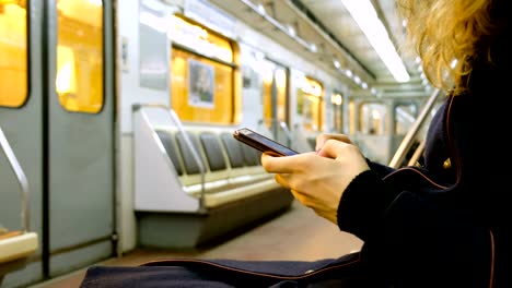 Woman-uses-a-smartphone-in-the-subway-close-up