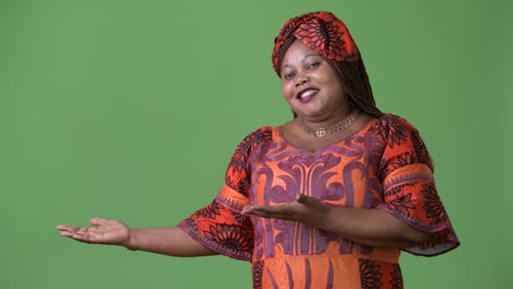 Overweight-beautiful-African-woman-wearing-traditional-clothing-against-green-background