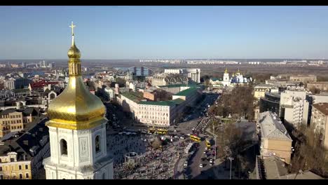 A-bird's-eye-view,-panoramic-video-from-the-drone-in-FullHD-to-the-Saint-Sophia's-Cathedral,-Sofiyivska-Square,-left-bank-of-city-in-the-city-of-Kiev,-Ukraine.-People-on-the-square-on-Easter-days.