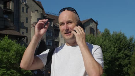 Hombre-de-las-gafas-de-sol-llamando-y-hablando-por-teléfono-en-la-ciudad-de