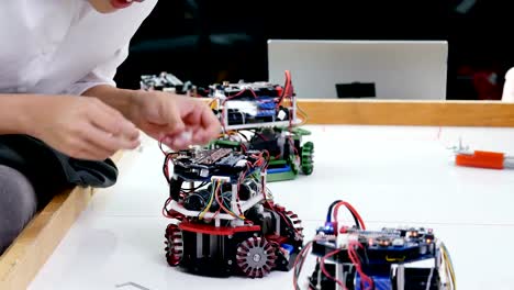 Electronics-engineers-working-and-testing-mini-robot-in-laboratory.