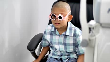 eyesight-check.-Asian-boys-who-have-vision-disabilities.-Left-eye-is-not-visible-from-brain-surgery.-Medical-treatment-and-Rehabilitation