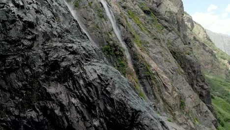 Tracking-and-top-shot-Air-shot-from-a-stream-of-water-splashing-waterfall-on-a-rock-wall-in-the-Caucasus-Mountains.-Around-the-jet-of-the-waterfall