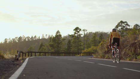 Radfahrer-sitzen-auf-einem-Fahrrad-auf-einem-Smartphone-für-social-Networking-Berglandschaft-bei-Sonnenuntergang-fotografieren.-Slow-motion