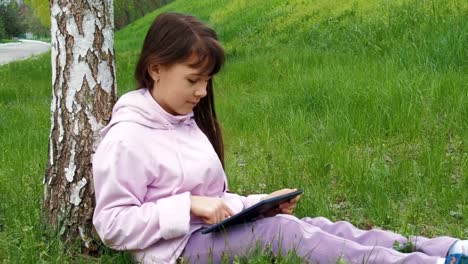 Ein-Kind-mit-einem-Tablet-auf-die-Natur.