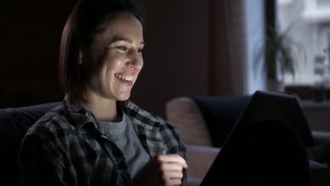 Happy-woman-using-digital-tablet-at-night