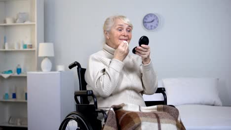 Smiling-disabled-woman-applying-skin-powder,-beauty-in-old-age,-make-up-tricks