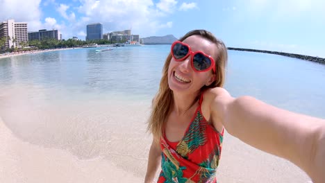 Selfie-von-Mädchen-mit-Herz-geformt-Sonnenbrille-am-Strand-von-Hawaii.-Junge-Frau,-die-eine-Selfie-am-Strand-von-Waikiki-in-Honolulu.-Hawaii-USA