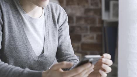 Woman-chatting-with-her-smartphone-at-home