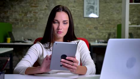 Businesswoman-works-attentively-with-the-tablet-in-the-office