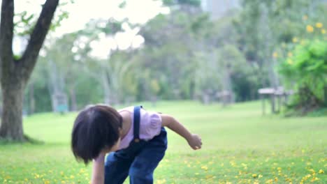 Cute-little-child-girl-on-Easter-day.-Girl-hunts-for-Easter-eggs-on-the-lawn-and-bunny-Made-of-paper-in-nature-or-park-and-sunlight.-Slow-Motion