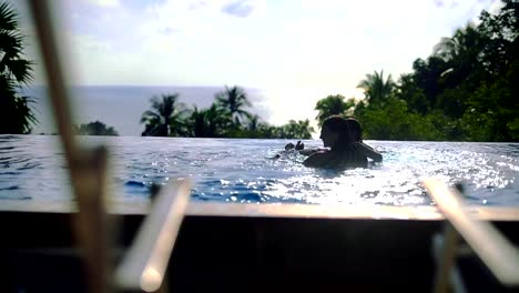 Two-girls-playing-in-the-outdoor-pool-on-a-sunny-day