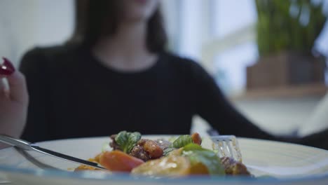 Junge-hübsche-Mädchen-mit-roter-Maniküre-Salz-ihr-leckeres-Appetitgericht-sitzen-in-gemütlichem-Restaurant.