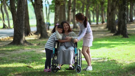 Madre-en-silla-de-ruedas-y-dos-adorable-hija-en-el-Parque