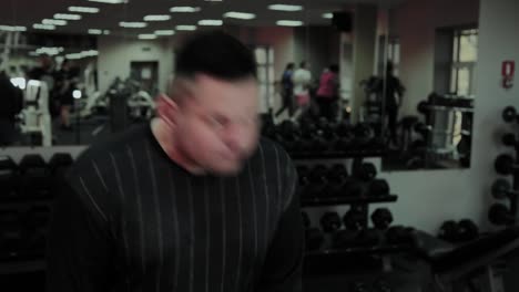 Cheerful-fat-man-performs-a-wrong-exercise-in-the-gym.-For-the-first-time-in-a-fitness-club