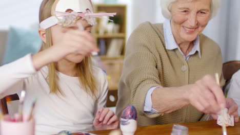 Mädchen-bemalten-Eier-zusammen-mit-Familie