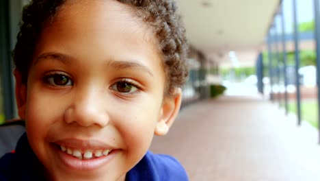 Close-up-del-colegial-feliz-afro-americano-con-discapacidades-sentado-en-silla-de-ruedas-en-el-corredor-escolar-4k