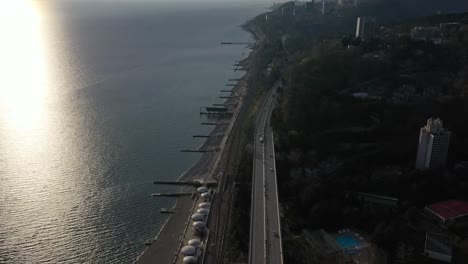 Aerial-video-shooting.-The-black-sea-coast-of-Sochi.-Road-along-the-coast.-Sunset-over-the-horizon.-Panorama-shooting.