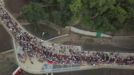 A-crowd-of-people-on-a-pedestrian-bridge-in-the-spring-evening.-Aerial-view.-A-new-bicycle-pedestrian-bridge-in-the-center-of-the-capital-of-Ukraine,-the-city-of-Kiev.-Excursions-and-walks-for-tourist