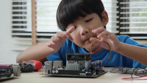 Junge-versuchen,-Computer-Board-in-Schulwissenschaft-Club-zu-fixieren.-Projekt-für-Ingenieurclub-in-der-Schule.-Menschen-mit-Technologiekonzept.