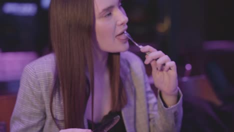 Cute-young-woman-eating-meat-grilled-with-vegetable-in-the-modern-restaurant.