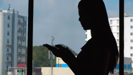 Mujer-hablando-por-teléfono-en-la-ventana