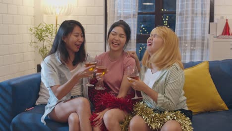 Group-of-Asian-women-party-at-home,-female-drinking-cocktail-talking-having-funny-together-on-sofa-in-living-room-in-night.-Teenager-young-friend-play-game,-friendship,-celebrate-holiday-concept.