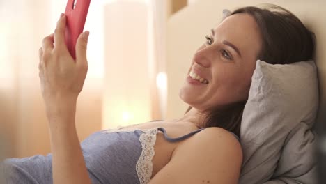 Woman-video-chatting-using-mobile-phone-in-bed