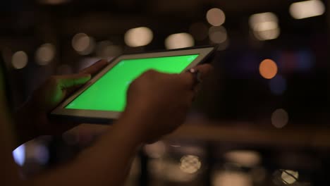 Hands-of-young-Asian-man-using-digital-tablet-at-night