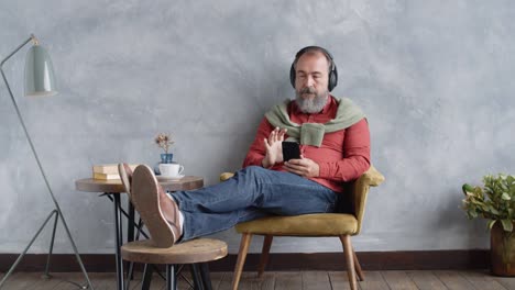 Hombre-Senior-Disfrutando-de-la-música-a-través-de-auriculares-en-casa