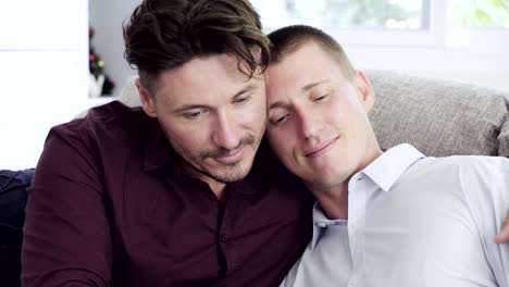 Pareja-gay-relajándose-en-el-sofá.-Un-beso-pequeño.