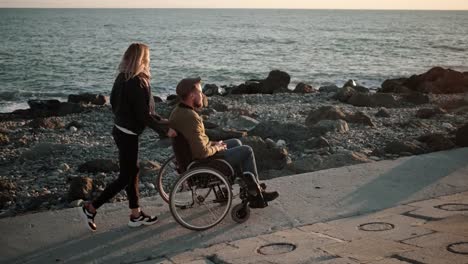 Girl-with-handicapped-boyfriend-walking-along-the-sea