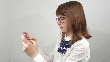 schoolgirl-in-glasses-texting-on-social-networks-with-friends