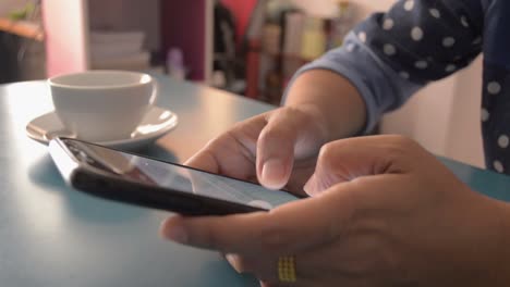 Woman-using-smart-phone-on-the-desk-at-home.