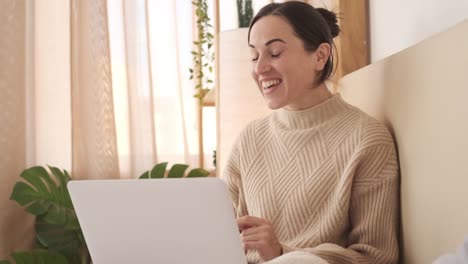 Frau-macht-Videoanruf-mit-Laptop-auf-dem-Bett