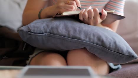 Closeup-of-tablet-and-woman-writing-a-book-in-blurred-background.